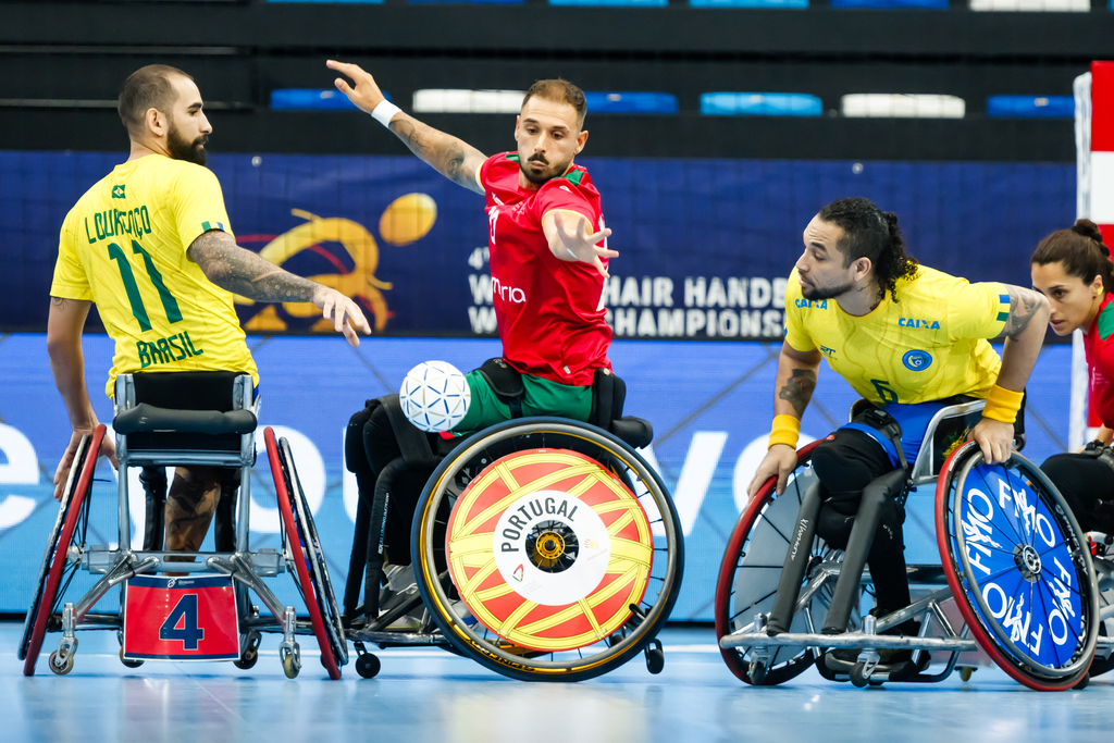 Wheelchair athletes from Brazil, Portugal, and Sweden compete in an indoor wheelchair handball match.